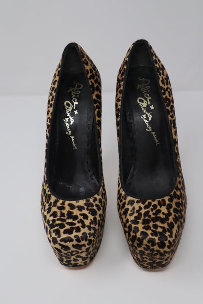 A bold pair of Alice + Olivia by Stacey Bendet platform pumps featuring luxurious pony hair with a striking leopard print. These shoes have a stiletto heel and a platform base, combining both height and comfort, perfect for making a statement with any outfit.