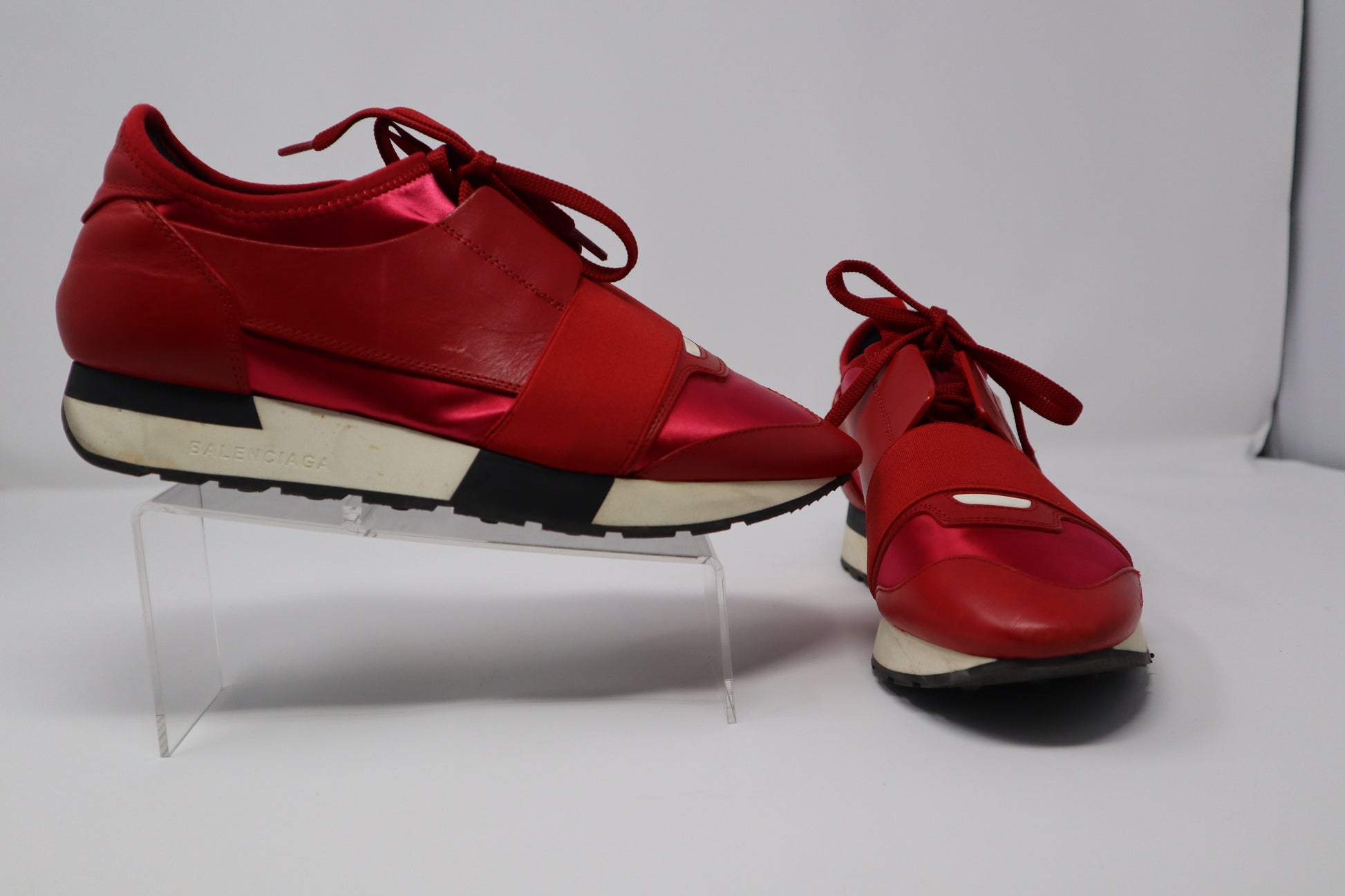 Balenciaga Race Runner Sneakers featuring a mix of leather, mesh, and neoprene with a signature elastic strap across the midfoot. The sneakers have a sporty yet high-fashion design with a rubber sole for durability. Condition: Good, with slight signs of wear, no box included