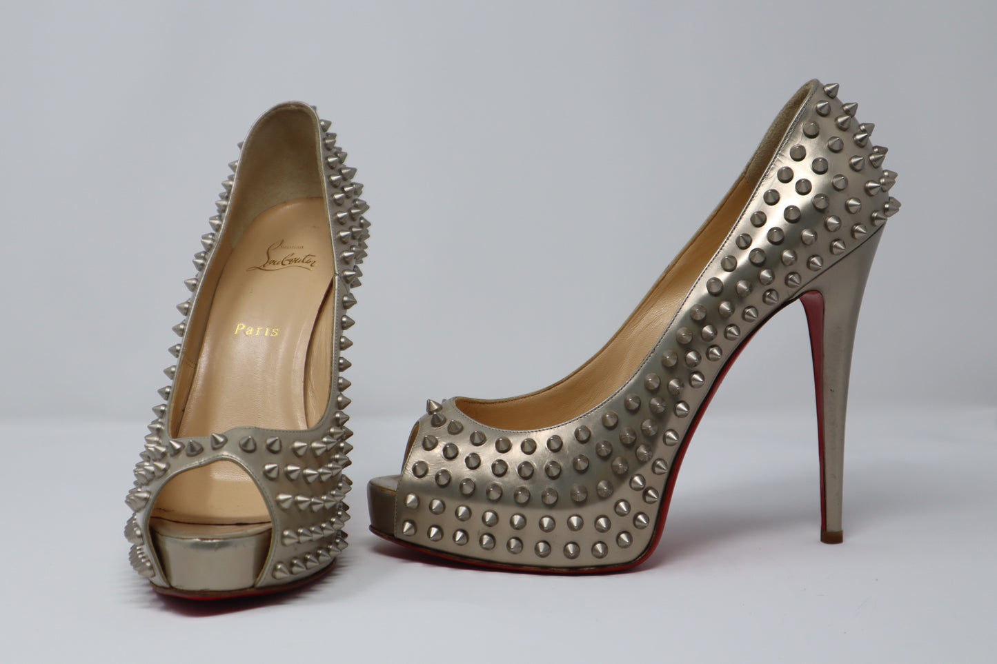 Christian Louboutin Silver Glitter Leather Flo Pumps featuring a pointed toe, mid-height stiletto heel, and iconic red sole. These pumps are crafted from sparkling silver glitter leather, perfect for adding glamour and elegance to any occasion.