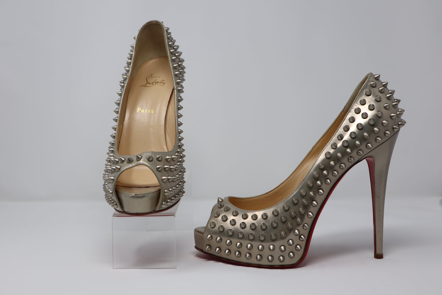 Christian Louboutin Silver Glitter Leather Flo Pumps featuring a pointed toe, mid-height stiletto heel, and iconic red sole. These pumps are crafted from sparkling silver glitter leather, perfect for adding glamour and elegance to any occasion.