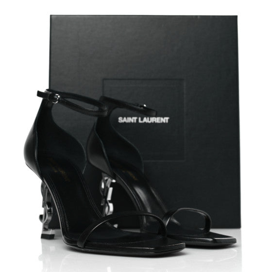 Saint Laurent Calfskin Opyum 85 Sandals, designed with smooth calfskin leather, featuring a sleek stiletto heel with the iconic YSL logo, and a minimalist ankle strap for an elegant and modern silhouette.